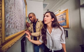 Two guests examine clues inside The Heist escape room at The Escape Game in Gilbert, Arizona.