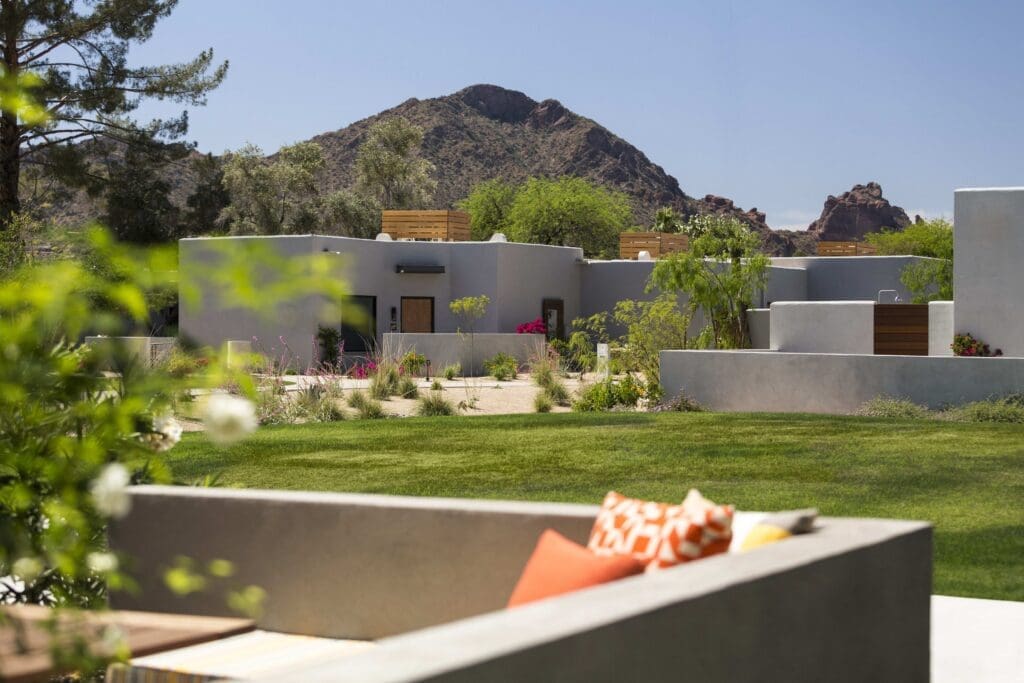 Andaz Scottsdale Resort & Bungalows with green landscaping area and concrete seating with pillows.