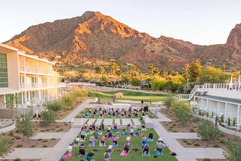 Mountain Shadows Resort in Arizona with people doing yoga on the lawn and mountain in the background.