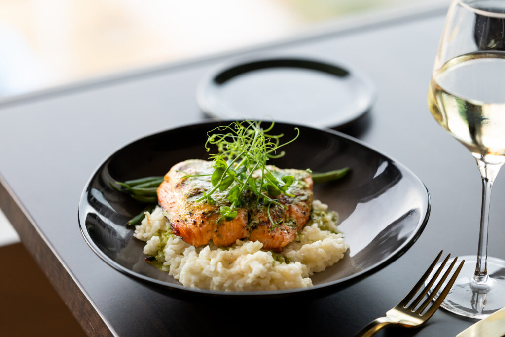 Scottish salmon served with risotto and seasonal vegetables at Longmont Supply rooftop restaurant.
