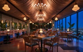 Oleander dining room with chandeliers and panoramic Los Angeles views at The Sun Rose West Hollywood.