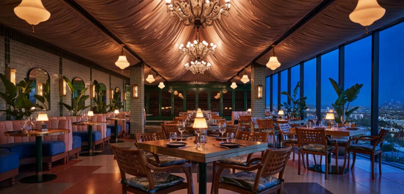Oleander dining room with chandeliers and panoramic Los Angeles views at The Sun Rose West Hollywood.