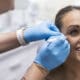 A Facial Aesthetics provider prepares a patient for an injectable treatment near her eye.
