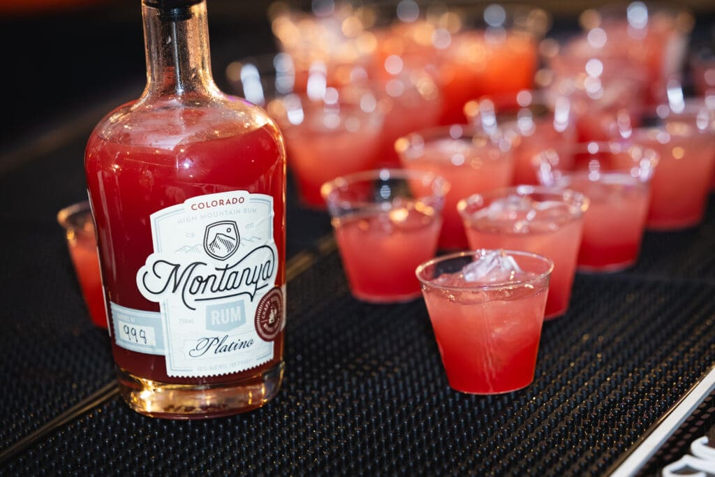 Pink cocktails served alongside a bottle of Montanya rum at a previous RARE Steak Championship.
