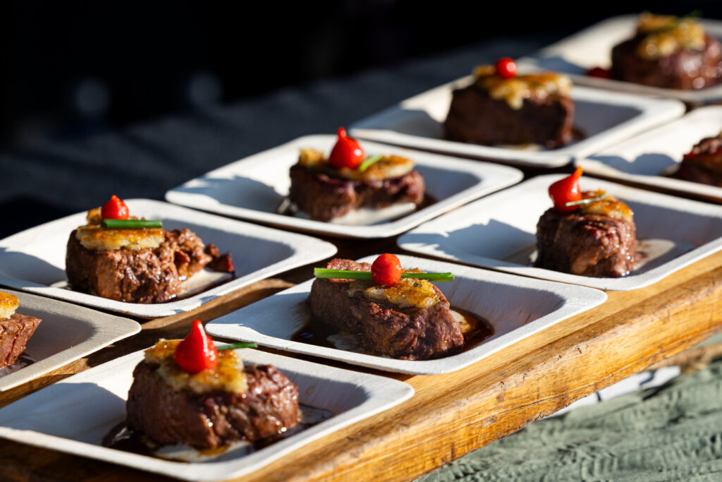 Individual steak tastings topped with garnishes and arranged on plates at a previous RARE Steak Championship.
