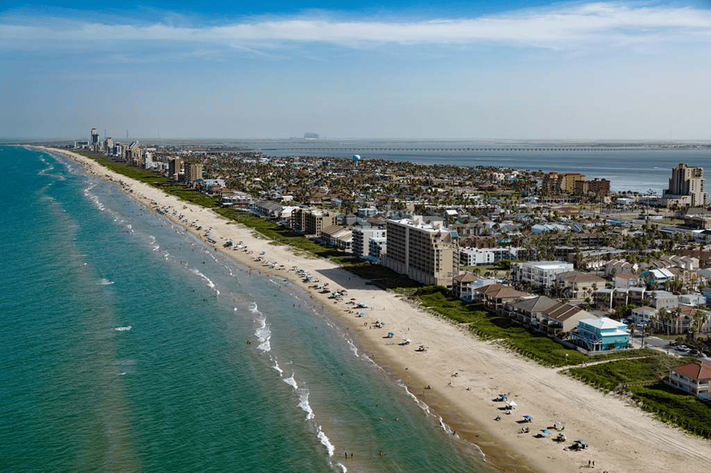 Aerial view of South Padre Island showing the Gulf of Mexico, sandy beach, hotels, homes and Laguna Madre.