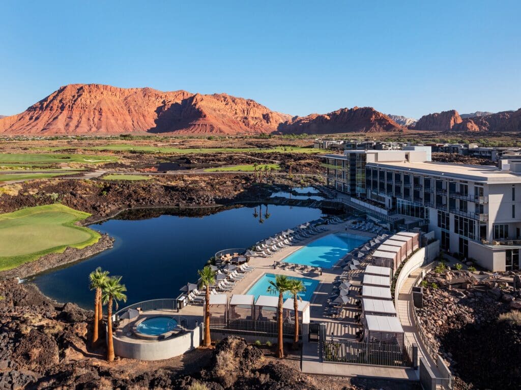 An aerial view of the Black Desert Resort with guest building, pool and Zion mountains in the background.