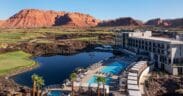 An aerial view of the Black Desert Resort with guest building, pool and Zion mountains in the background.