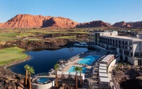An aerial view of the Black Desert Resort with guest building, pool and Zion mountains in the background.