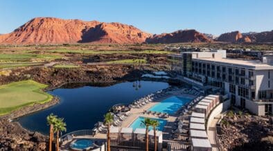 An aerial view of the Black Desert Resort with guest building, pool and Zion mountains in the background.
