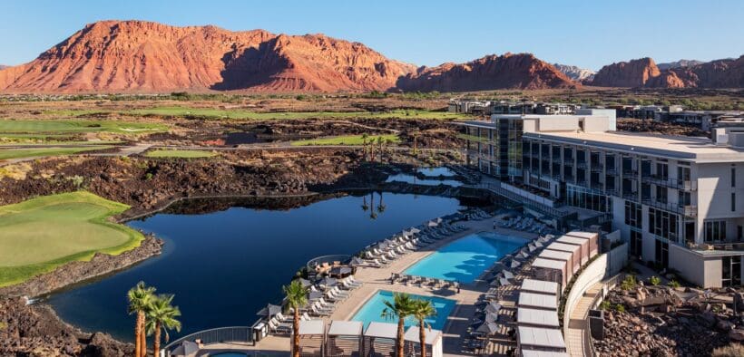 An aerial view of the Black Desert Resort with guest building, pool and Zion mountains in the background.