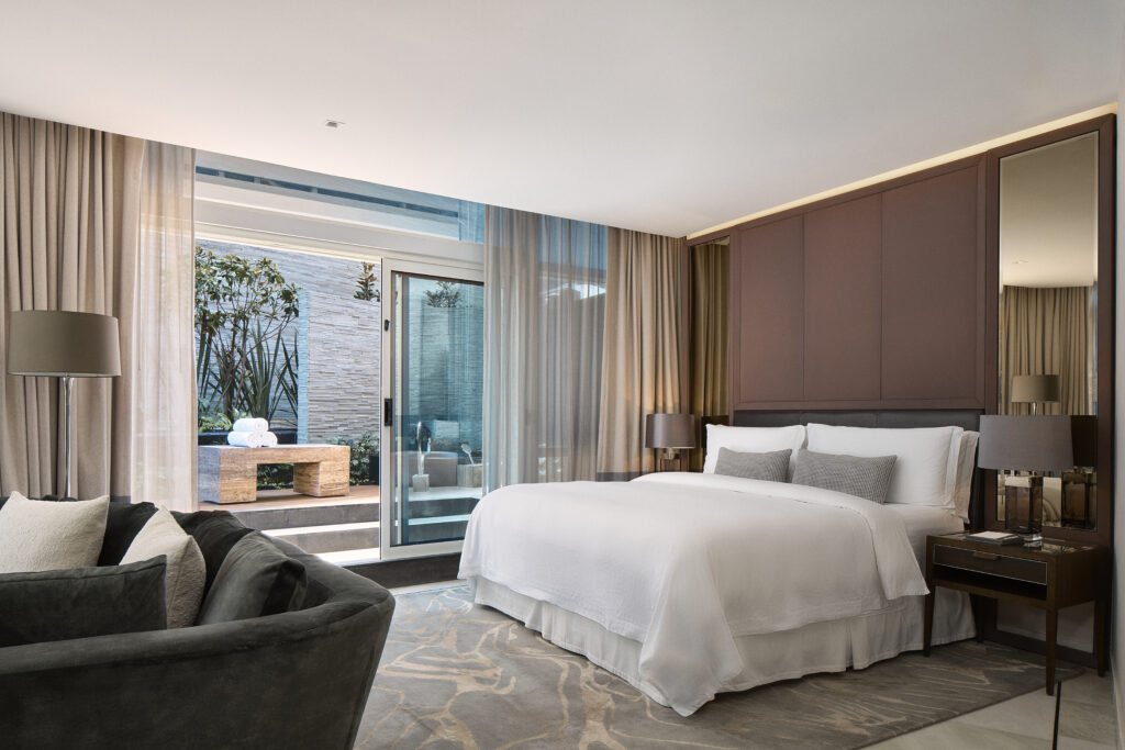 Renovated guest room with king bed, curved sofa and private outdoor space at The St. Regis Mexico City.