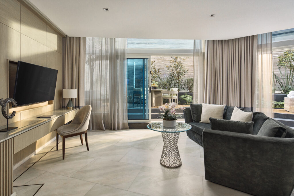 Renovated guest room living area with curved sofa and private terrace at The St. Regis Mexico City.