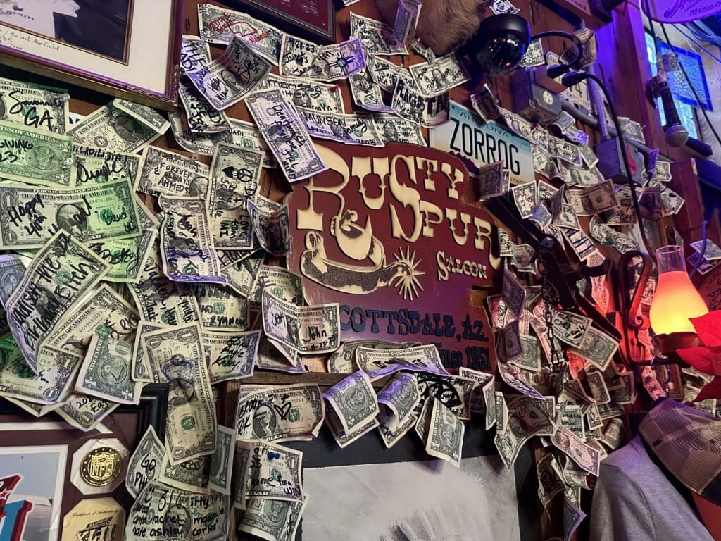 Signed dollar bills cover the walls surrounding the Rusty Spur Saloon sign in Old Town Scottsdale.