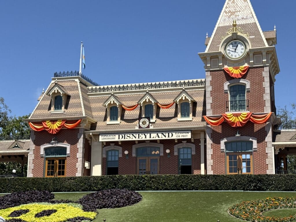 Disneyland Park entrance decorated with orange and yellow bunting for Halloween Time.