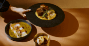 El Sol tasting menu with tiradito, braised short rib and pumpkin crème brûlée arranged in golden light at Tamayo in Denver.