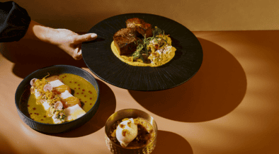 El Sol tasting menu with tiradito, braised short rib and pumpkin crème brûlée arranged in golden light at Tamayo in Denver.