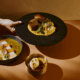 El Sol tasting menu with tiradito, braised short rib and pumpkin crème brûlée arranged in golden light at Tamayo in Denver.