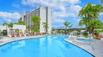 Outdoor swimming pool and hot tub surrounded by palm trees at Hilton Irvine in Orange County, California.