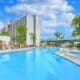 Outdoor swimming pool and hot tub surrounded by palm trees at Hilton Irvine in Orange County, California.
