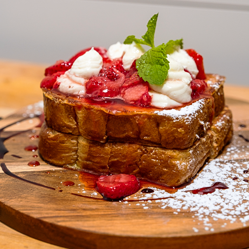 Thick-cut sweet brunch dish topped with strawberries, cream, powdered sugar and mint at Holla Brunch Girl.