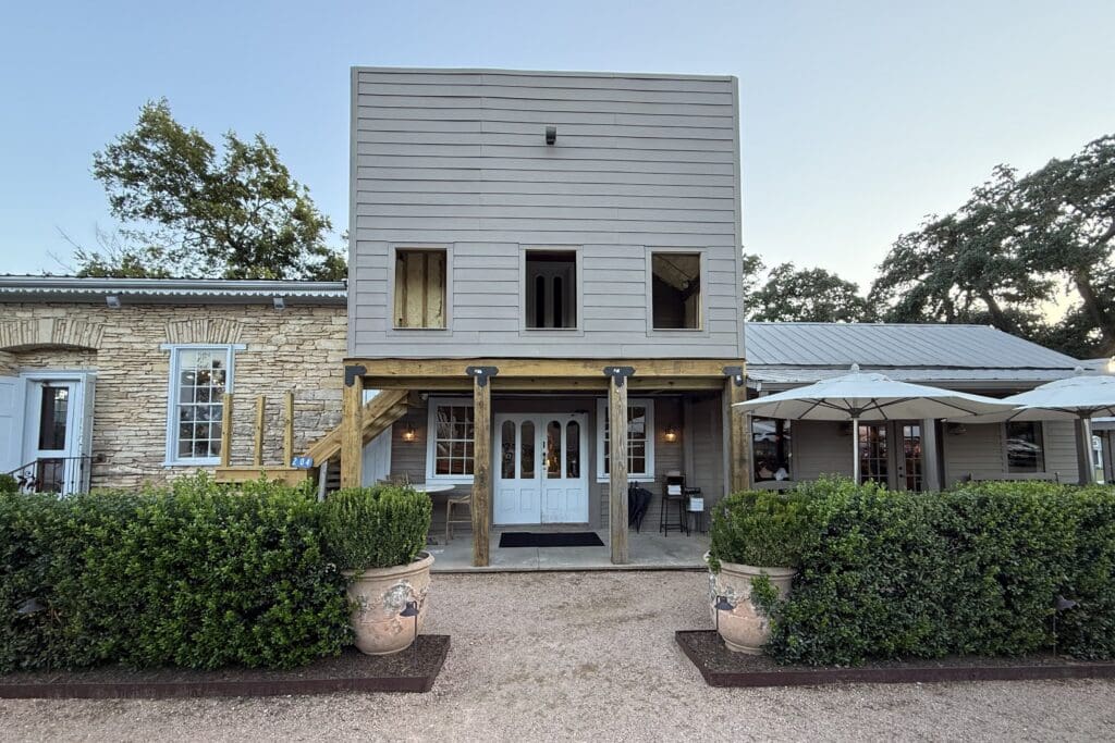 LuLu's in a historic building surrounded by hedges and outdoor seating at Henkel Square in Round Top, Texas.