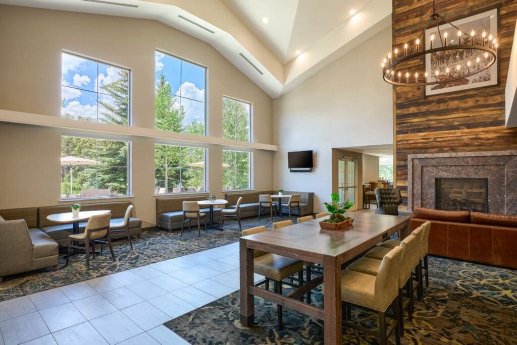 Renovated Residence Inn Breckenridge common area with fireplace, seating and large windows.