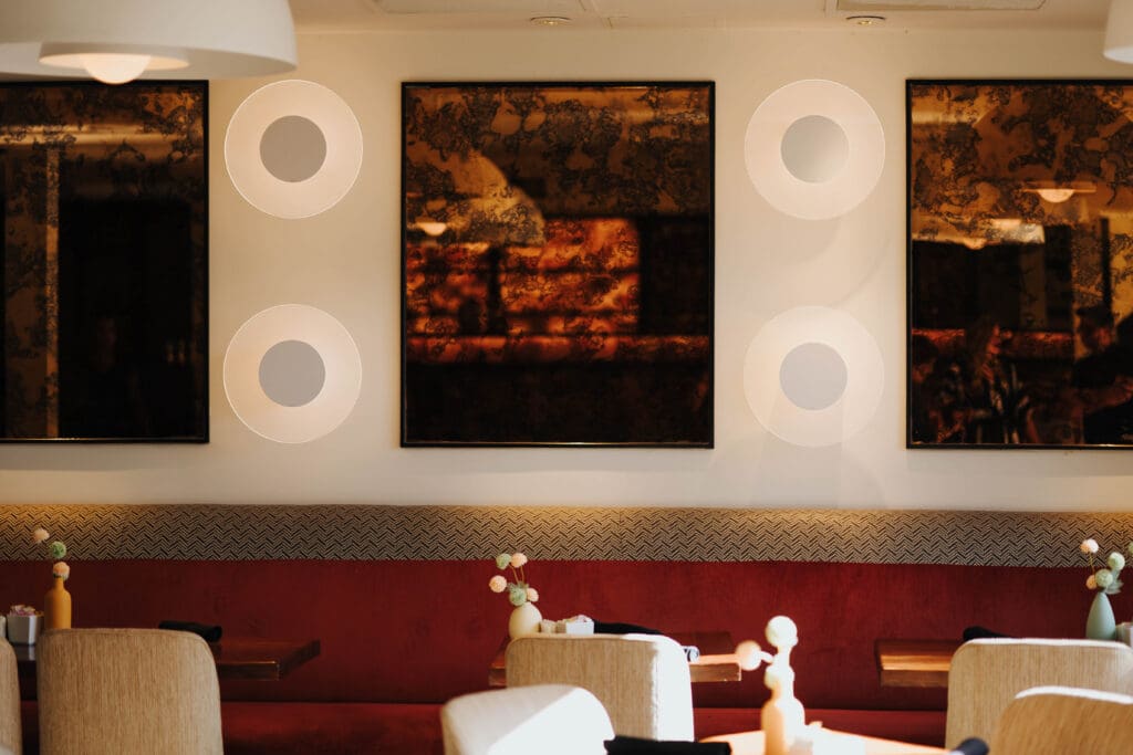 Interior of SaltRock Southwest Kitchen featuring red banquette seating, dining tables and abstract wall art.