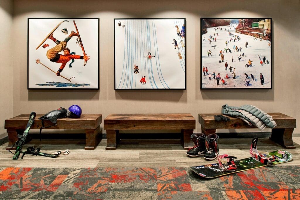 Ski and snowboard gear displayed beneath mountain artwork at Residence Inn Breckenridge.