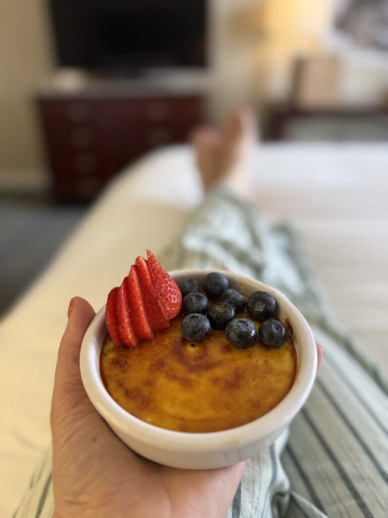 Berry-topped crème brûlée from Trellis & Tide held in a Hilton Irvine guest room.