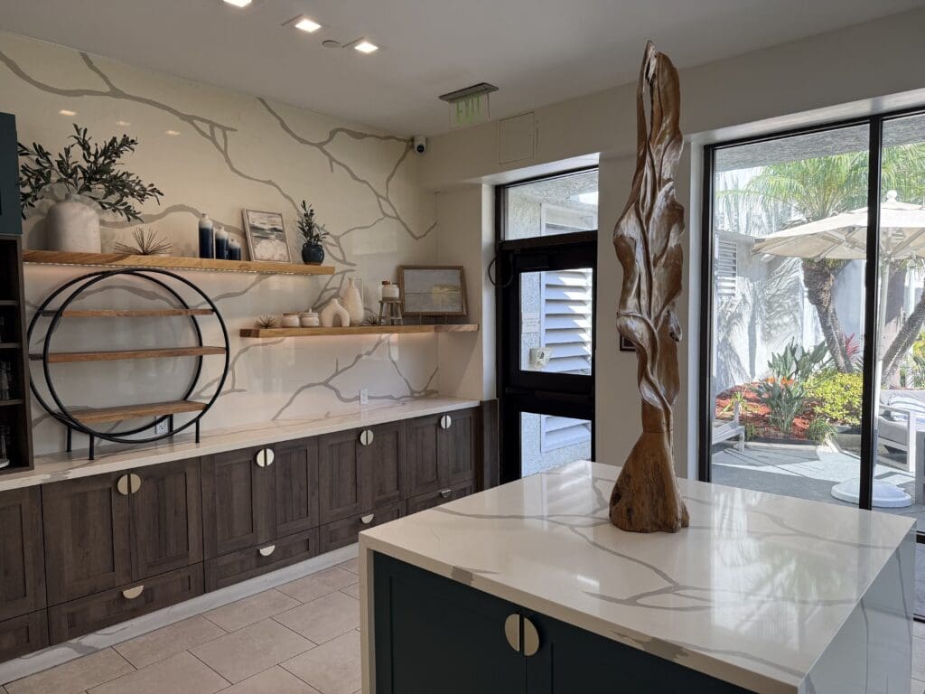 Interior of Trellis & Tide at Hilton Irvine with modern shelving, wood accents and views of the outdoor patio.
