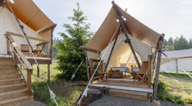 Under Canvas Kids Tent with two twin beds, a wooden deck and outdoor chairs.