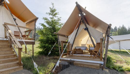 Under Canvas Kids Tent with two twin beds, a wooden deck and outdoor chairs.