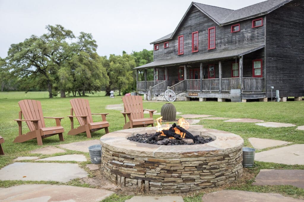 Star House at Wander Inn in Round Top with an outdoor stone fire pit and Adirondack chairs.
