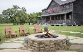 Star House at Wander Inn in Round Top with an outdoor stone fire pit and Adirondack chairs.