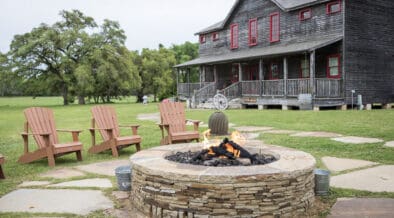Star House at Wander Inn in Round Top with an outdoor stone fire pit and Adirondack chairs.