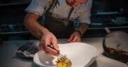 Chef Drew Anderson carefully plates a dish in the kitchen at Kai in Chandler, Arizona.