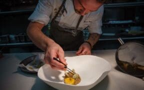 Chef Drew Anderson carefully plates a dish in the kitchen at Kai in Chandler, Arizona.
