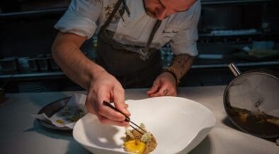 Chef Drew Anderson carefully plates a dish in the kitchen at Kai in Chandler, Arizona.