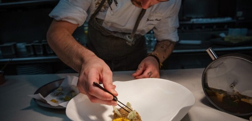Chef Drew Anderson carefully plates a dish in the kitchen at Kai in Chandler, Arizona.