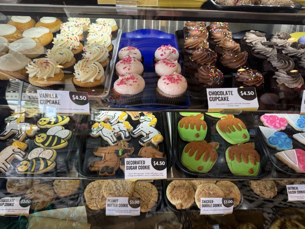 Display case filled with cupcakes and decorated sugar cookies at 2Tarts Bakery in New Braunfels.
