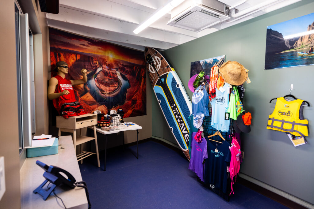 Paddleboard, life jacket, apparel and canyon photographs displayed inside the Desert Adventures space at the Boulder City Adventure Center.