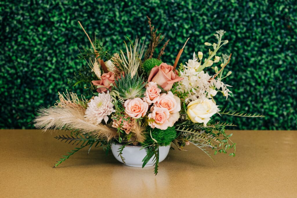Floral arrangement with roses, succulents, greenery and textured foliage at Cactus Flower Florists.
