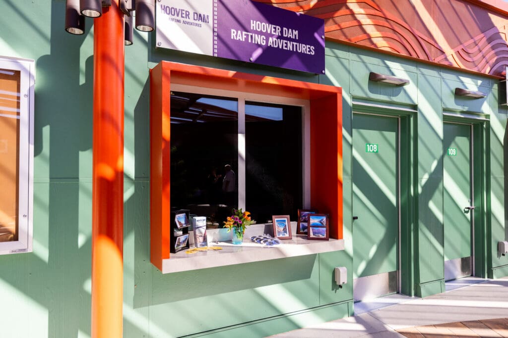 Hoover Dam Rafting Adventures service window with an orange frame and purple sign at the Boulder City Adventure Center.