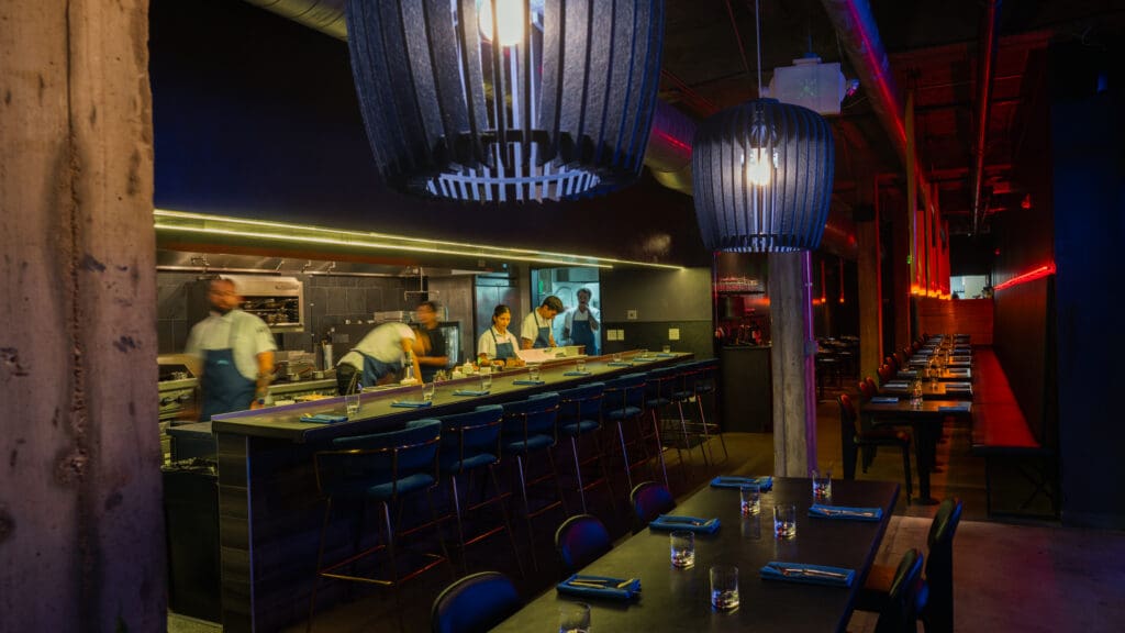 BearLeek dining room and open kitchen with blue and red lighting in Denver.