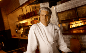 Chef Kim Canteenwalla stands inside a restaurant kitchen in Las Vegas.