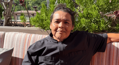Chef Linda Garcia seated on the rooftop terrace at Topside Terrace Kitchen & Bar in San Diego