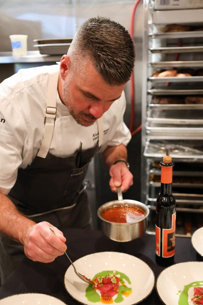 Chef Nick Zocco plating a colorful dish in the kitchen at Urban Hill in Salt Lake City.