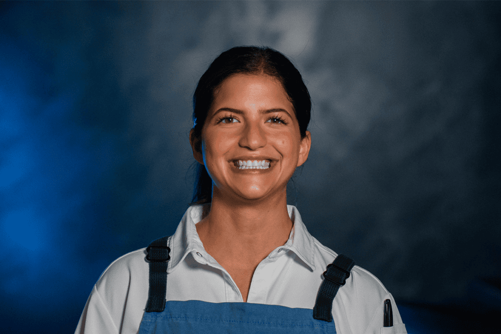 Chef Rema Maaliki wearing a blue apron at BearLeek in Denver.