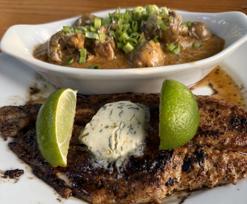 Grilled catfish topped with herb butter and served with lime wedges at Gristmill River Restaurant & Bar.